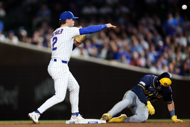 Chicago Cubs second baseman Nico Hoerner (2) throws to Chicago Cubs first baseman Michael Busch (29) to tag out Milwaukee Brewers catcher William Contreras (24) after tagging out Milwaukee Brewers outfielder Isaac Collins (6) at second in a double play during the fifth inning at Wrigley Field on Wednesday, Aug. 20, 2025, in Chicago. (Armando L. Sanchez/Chicago Tribune)