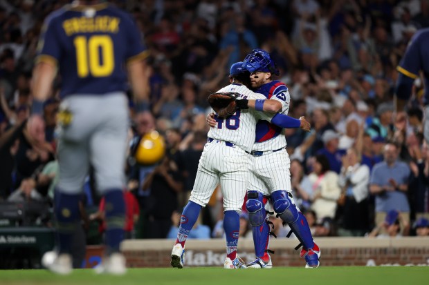 Chicago Cubs pitcher Daniel Palencia (48) hugs Chicago Cubs catcher Carson Kelly (15) after getting the last out to give the Cubs a 4-3 win over the Milwaukee Brewers at Wrigley Field on Wednesday, Aug. 20, 2025, in Chicago. (Armando L. Sanchez/Chicago Tribune)