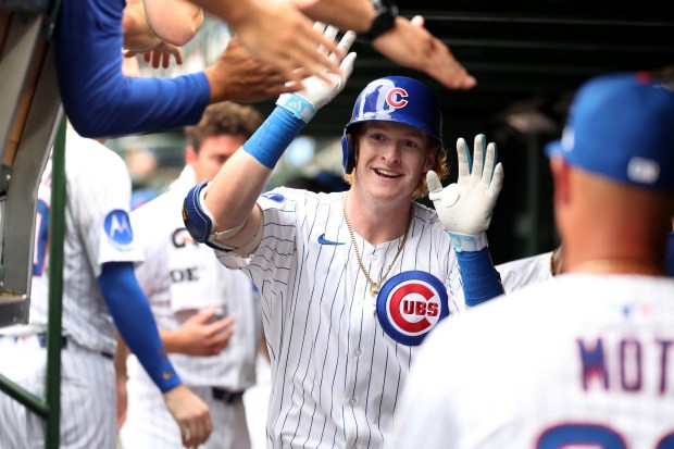 Chicago Cubs right fielder Owen Caissie is congratulated by his teammates in the dugout after hitting a solo home run in the sixth inning of Game 1 of a doubleheader against the Milwaukee Brewers at Wrigley Field in Chicago on Aug. 19, 2025. It was his first major league home run. (Chris Sweda/Chicago Tribune)
