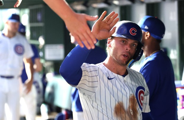 Chicago Cubs second baseman Nico Hoerner is congratulated in the dugout after scoring on a single by teammate Owen Caissie in the second inning of Game 2 of a doubleheader against the Milwaukee Brewers at Wrigley Field in Chicago on Aug. 19, 2025. (Chris Sweda/Chicago Tribune)