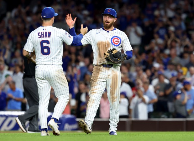 Chicago Cubs third baseman Matt Shaw (6) and first baseman Michael Busch (right) celebrate after their victory over the Milwaukee Brewers in Game 2 of a doubleheader at Wrigley Field in Chicago on Aug. 19, 2025. (Chris Sweda/Chicago Tribune)