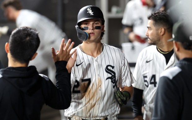 Chicago White Sox left fielder Brooks Baldwin (27) is congratulated in the dugout after scoring on a single by teammate Kyle Teel in the sixth inning of a game against the Kansas City Royals at Rate Field in Chicago on Aug. 26, 2025. (Chris Sweda/Chicago Tribune)