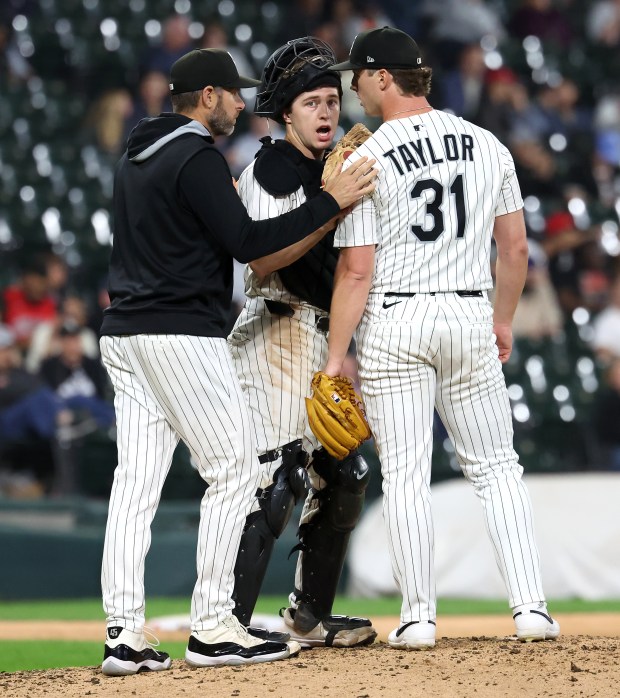 Chicago White Sox relief pitcher Grant Taylor (31) chats with catcher Kyle Teel and pitching coach Ethan Katz (left) in the ninth inning of a game against the Kansas City Royals at Rate Field in Chicago on Aug. 26, 2025. (Chris Sweda/Chicago Tribune)