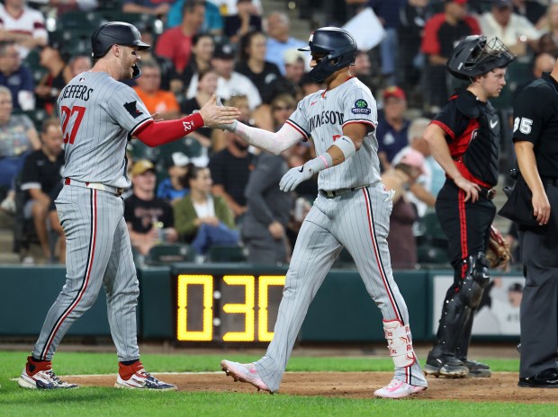 Minnesota Twins third baseman Royce Lewis is congratulated by teammate Ryan Jeffers (left) after Lewis hit a grand slam in the fourth inning of a game against the Chicago White Sox at Rate Field in Chicago on Aug. 22, 2025. (Chris Sweda/Chicago Tribune)