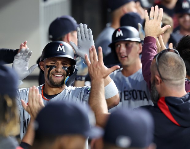 Minnesota Twins third baseman Royce Lewis is congratulated by his teammates in the dugout after hitting a grand slam in the fourth inning of a game against the Chicago White Sox at Rate Field in Chicago on Aug. 22, 2025. (Chris Sweda/Chicago Tribune)