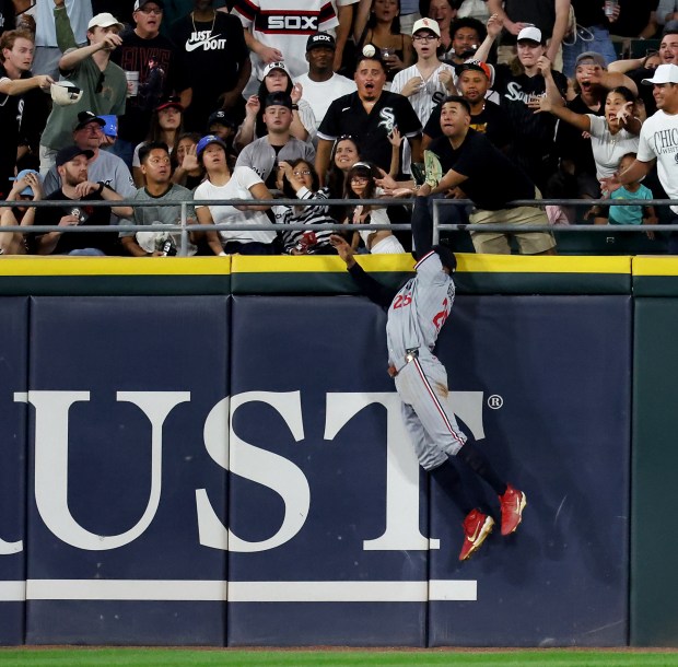 Minnesota Twins outfielder Byron Buxton (25) leaps, but is unable to catch, a ball that went for a twp-run home run for Chicago White Sox shortstop Colson Montgomery in the fifth inning of a game at Rate Field in Chicago on Aug. 22, 2025. (Chris Sweda/Chicago Tribune)