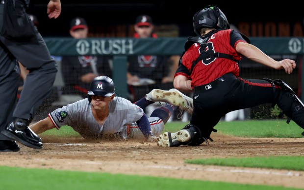 Minnesota Twins shortstop Brooks Lee sprints around to score in front of the tag of Chicago White Sox catcher Kyle Teel in the seventh inning of a game at Rate Field in Chicago on Aug. 22, 2025.  (Chris Sweda/Chicago Tribune)