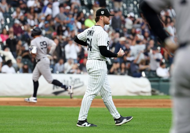 Chicago White Sox pitcher Shane Smith (64) walks off the mound as New York Yankees designated hitter Aaron Judge (background) rounds the bases after Judge hit a solo home run in the fourth inning of a game at Rate Field in Chicago on Aug. 30, 2025.  (Chris Sweda/Chicago Tribune)