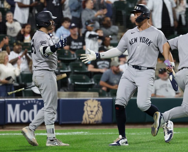 Yankees designated hitter Aaron Judge, right, slaps hands with Austin Wells after scoring in the 11th inning against the White Sox on Aug. 30, 2025, at Rate Field. (Chris Sweda/Chicago Tribune)