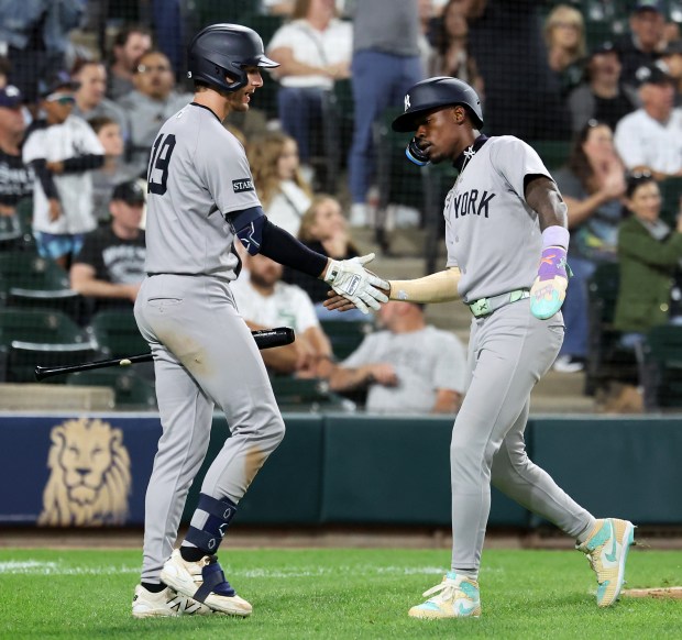 New York Yankees second baseman Jazz Chisholm Jr. (right) is congratulated by teammate Ryan McMahon (left) after Chisholm Jr. scored on a double by Anthony Volpe in the 11th inning of a game against the Chicago White Sox at Rate Field in Chicago on Aug. 30, 2025. (Chris Sweda/Chicago Tribune)