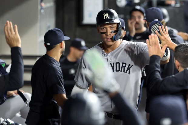 New York Yankees designated hitter Aaron Judge is congratulated by his teammates in the dugout after scoring on a sacrifice fly by Jazz Chisholm Jr. in the fifth inning of a game against the Chicago White Sox at Rate Field in Chicago on Aug. 28, 2025. (Chris Sweda/Chicago Tribune)