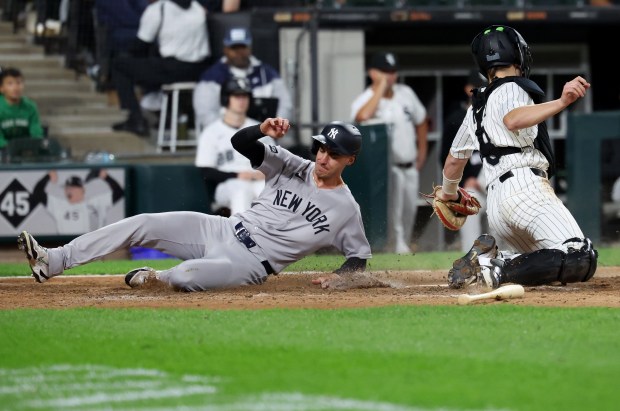 New York Yankees left fielder Cody Bellinger slides in safely at home to score in front of the tag of Chicago White Sox catcher Kyle Teel in the ninth inning of a game at Rate Field in Chicago on Aug. 28, 2025. (Chris Sweda/Chicago Tribune)