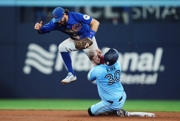 Toronto Blue Jays' Alejandro Kirk, right, slides safely into second base as Chicago Cubs shortstop Dansby Swanson (7) defends during the fifth inning of a baseball game in Toronto on Tuesday, Aug. 12, 2025. (Nathan Denette/The Canadian Press via AP)