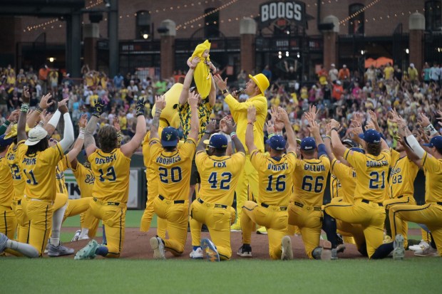 The Savannah Bananas and co-owner Jesse Cole sing "The Circle of Life" as a baby in a banana costume is held in the air before the Bananas play the Firefighters at Oriole Park at Camden Yards on Aug. 1, 2025, in Baltimore. (Kim Hairston/Baltimore Sun)
