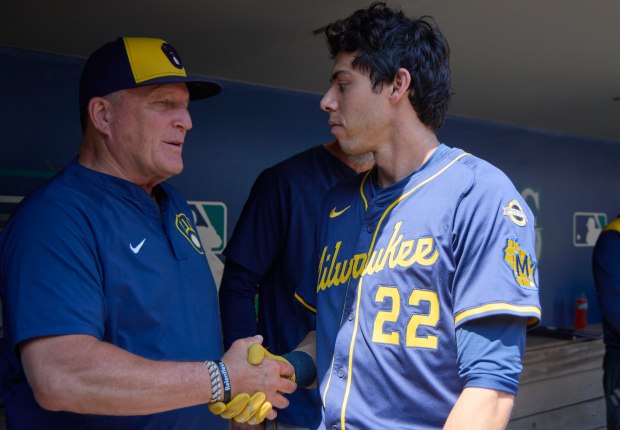 Brewers manager Pat Murphy, left, shakes hands with Christian Yelich in the dugout before a game against the Mariners on July 23, 2025, in Seattle. (John Froschauer/AP)