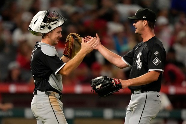 Catcher Kyle Teel, left, and reliever Jordan Leasure slap hands after the White Sox defeated the Angels 1-0 on Aug. 2, 2025, in Anaheim, Calif. (Mark J. Terrill/AP)