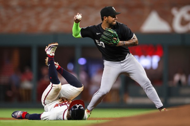 Chicago White Sox second baseman Lenyn Sosa (50) throws to first base after tagging out Atlanta Braves' Ozzie Albies, left, in the seventh inning of a baseball game, Tuesday, Aug. 19, 2025, in Atlanta. (AP Photo/Colin Hubbard)