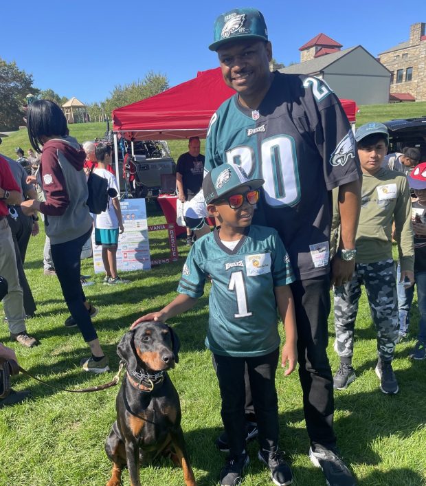 Will Crabbe of Glen Mills and his son Prince, 6, enjoyed meeting search and rescue dog Nellie at the 2023 Sunny Day Camp. (PEG DEGRASSA/ DAILY TIMES)