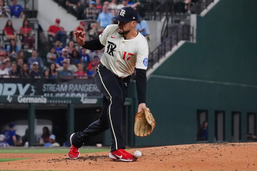 Texas Rangers starting pitcher Nathan Eovaldi reaches for a groundout hit by Cleveland...