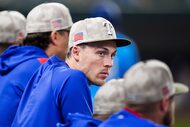Texas Rangers outfielder Evan Carter watches from the dugout during the eighth inning of a...