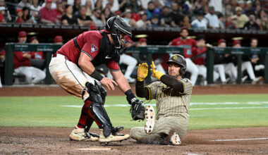 Jose Iglesias #7 of the San Diego Padres is tagged out at home by James McCann #8 of the Arizona Di...