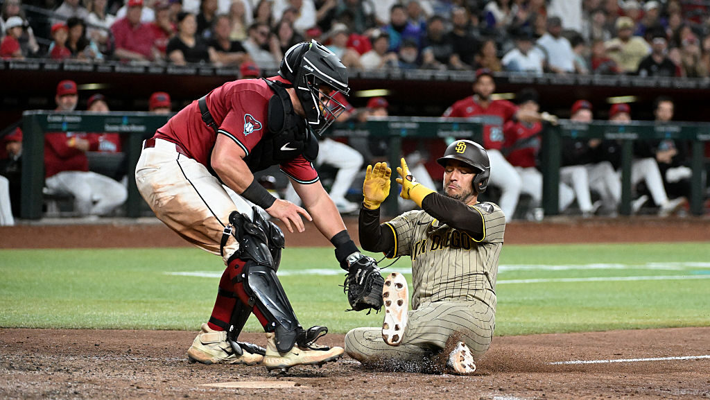 Jose Iglesias #7 of the San Diego Padres is tagged out at home by James McCann #8 of the Arizona Di...