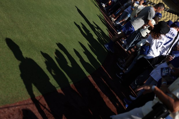 Dodgers utility man Tommy Edman (25) signs autographs before a...