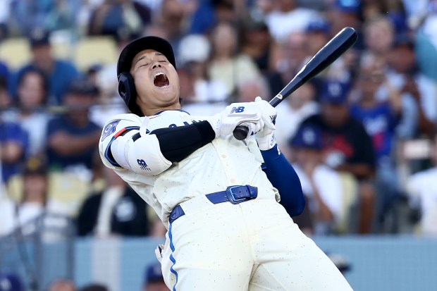 Dodgers star Shohei Ohtani reacts after avoiding an inside pitch...