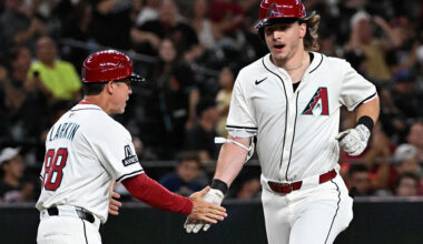 Jake McCarthy #31 of the Arizona Diamondbacks celebrates with third base coach Shaun Larkin...