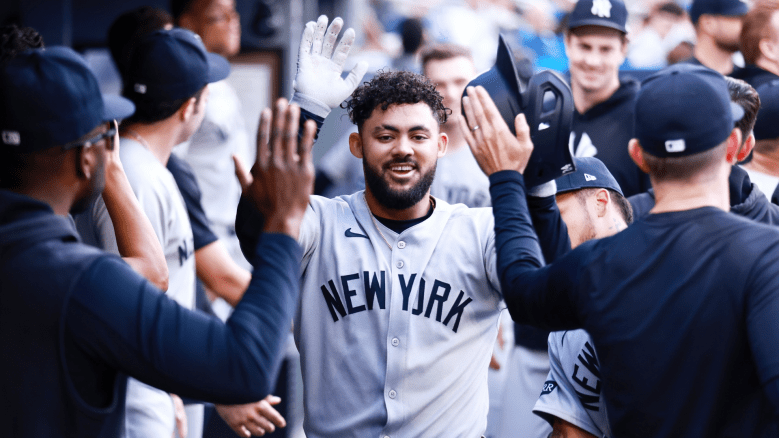 New York Yankees outfielder Jasson Dominguez fields throws while taking pregame practice at first base, sparking speculation about his future role.