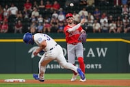 Los Angeles Angels' second baseman Luis Rengifo, right, throws to first base for a double...