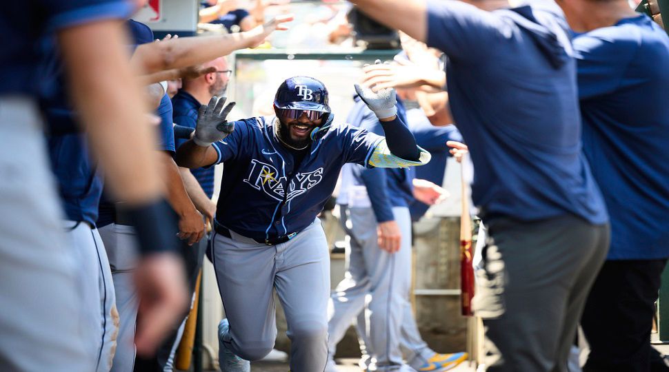 Tampa Bay Rays' Junior Caminero is greeted by teammates in the dugout after hitting a home run during the third inning of a baseball game against the Los Angeles Angels Wednesday, Aug. 6, 2025, in Anaheim, Calif. (AP Photo/William Liang)