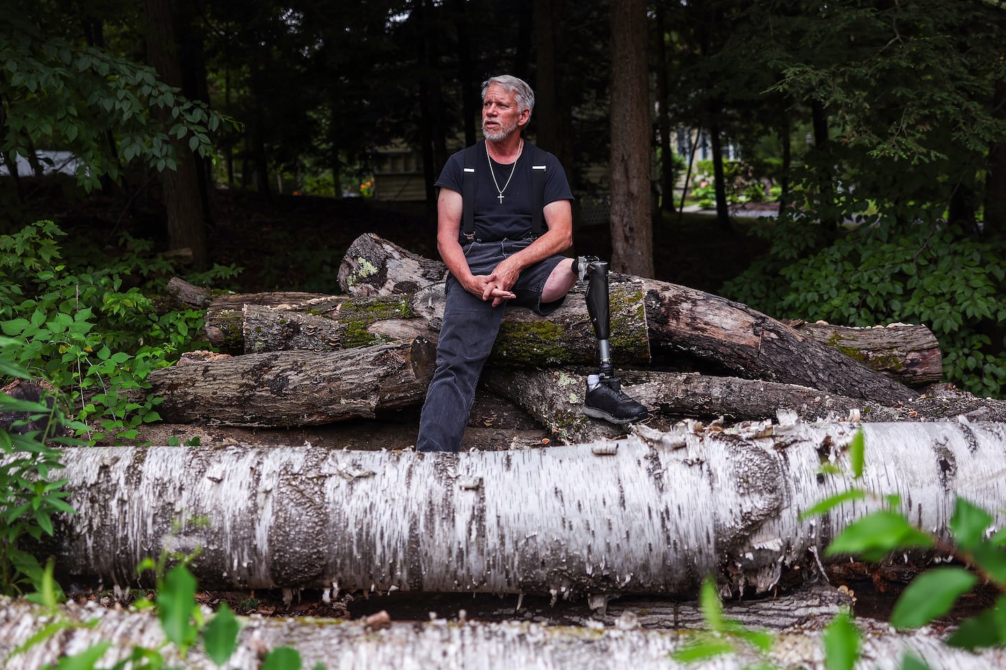Thomas Gee is one of the patients involved in clinical trials for a bionic knee developed by MIT researchers. He sat atop a stack of logs on his property in Litchfield, N.H., that he is cutting up for firewood, a job that would be much easier if he were wearing the MIT prosthetic, he said.