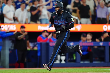 Toronto Blue Jays' Vladimir Guerrero Jr. (27) scores a run against the Texas Rangers during...