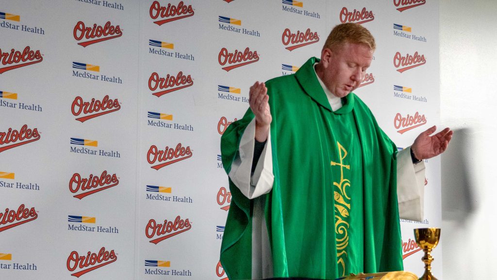 Dennis Baker S.J. in robes with arms outstretched