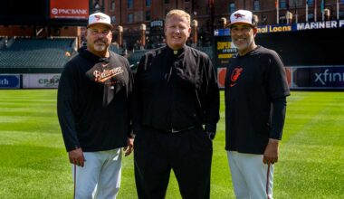Father Dennis Baker on field at Camden Yards