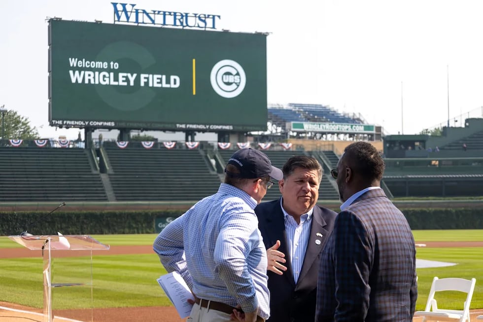 Senate President Don Harmon, left, and Chicago Mayor Brandon Johnson, right, speak to Gov. JB...