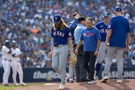 Texas Rangers pitcher Jon Gray, center front, leaves during the fifth inning of a baseball...