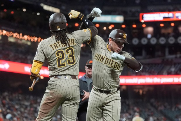 San Diego Padres' Freddy Fermin, right, is congratulated by Fernando Tatis Jr. (23) after hitting a two-run home run that also scored Jake Cronenworth during the seventh inning of a baseball game against the San Francisco Giants in San Francisco, Monday, Aug. 11, 2025. (AP Photo/Jeff Chiu)