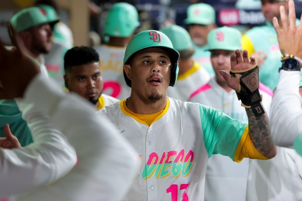 Manny Machado #13 of the San Diego Padres is congratulated in the dugout after scoring as run against the Los Angeles Dodgers during the fourth inning at Petco Park on Friday, Aug. 22, 2025 in San Diego, CA. (Meg McLaughlin / The San Diego Union-Tribune)