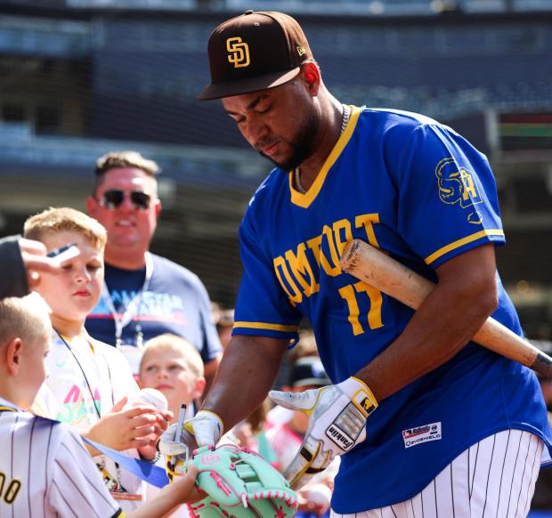 Elias Díaz #17 of the San Diego Padres, wearing a replica Comfort High School jersey from Comfort, Texas, signs autographs before a game against the Boston Red Sox at Petco Park on Aug. 9, 2025 in San Diego, CA. Both the Red Sox and Padres wore replica jerseys from Texas high schools affected by last month's flooding during batting practice. The jerseys will be auctioned off, with all proceeds donated to relief efforts. (Meg McLaughlin / The San Diego Union-Tribune)