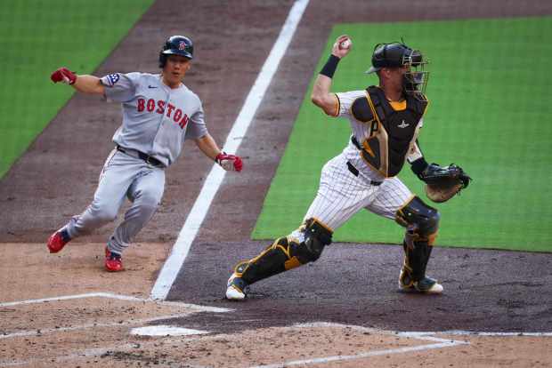 Freddy Fermin #54 of the San Diego Padres tags out Masataka Yoshida #7 of the Boston Red Sox at home and attempts to turn a double during the second inning at Petco Park on Saturday, Aug. 9, 2025 in San Diego, CA. (Meg McLaughlin / The San Diego Union-Tribune)