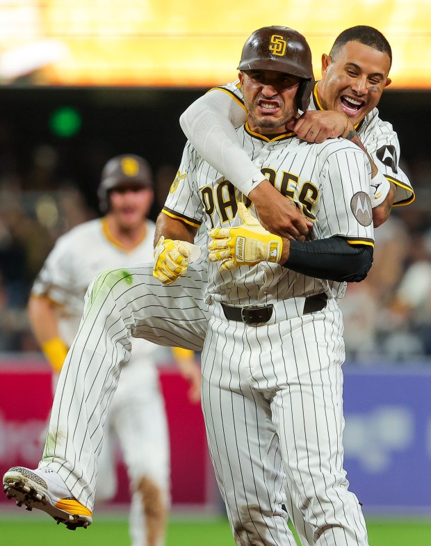 Manny Machado #13 and Ramon Laureano #5 of the San Diego Padres celebrate after Laureano hit a walk-off single against the Boston Red Sox during the tenth inning at Petco Park on Saturday, Aug. 9, 2025 in San Diego, CA. (Meg McLaughlin / The San Diego Union-Tribune)