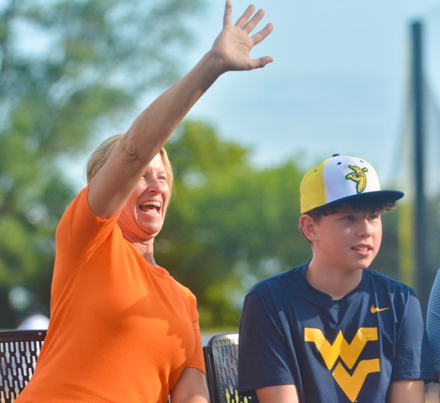 Baltimore Orioles groundskeeper Nicole Sherry, left, waves to the crowd...