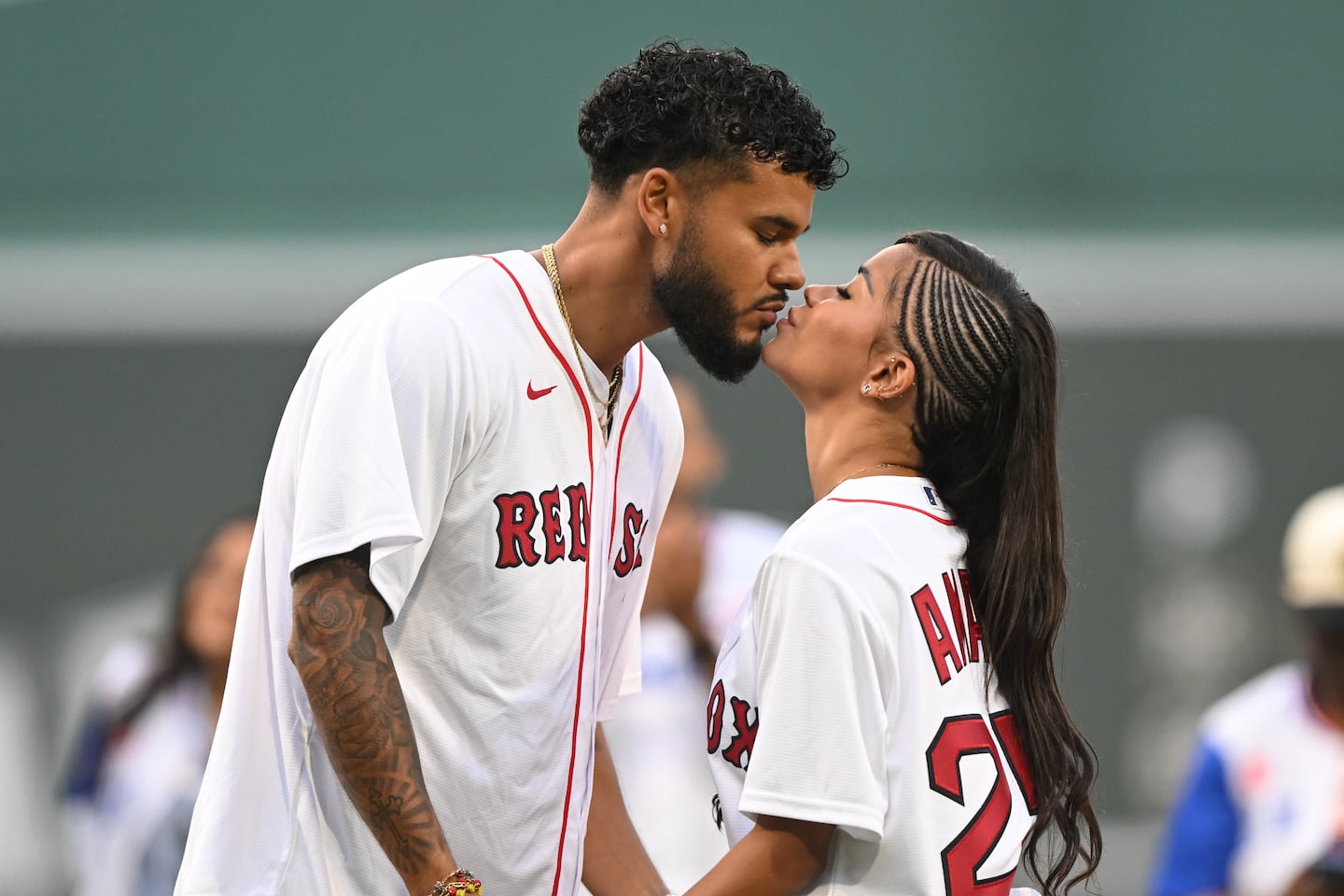 Amaya Espinal and Bryan Arenales of "Love Island USA" kissed after a ceremonial pitch before a game between the Kansas City Royals and the Red Sox on Aug. 4 at Fenway Park.