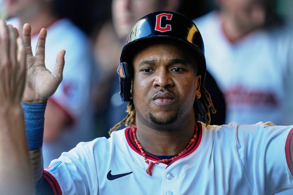 Cleveland Guardians' Jose Ramirez is congratulated in the dugout after scoring in the first...