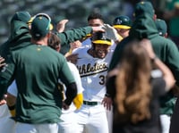 Oakland Athletics' Abraham Toro, middle, is congratulated by teammates after walking with the bases loaded during the ninth inning of a baseball game against the Cleveland Guardians in Oakland, Calif., Sunday, March 31, 2024.