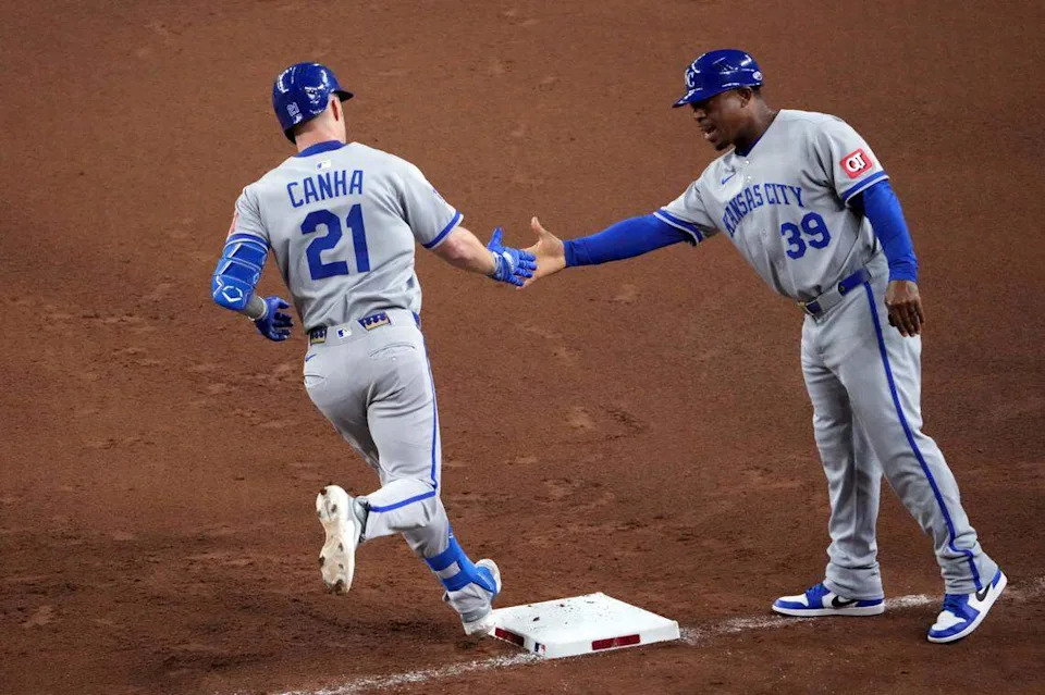 Kansas City Royals outfielder Mark Canha (21) slaps hands with Kansas City Royals first base coach Damon Hollins (39) after hitting a solo home run against the Arizona Diamondbacks during the fifth inning at Chase Field on July 4, 2025.
