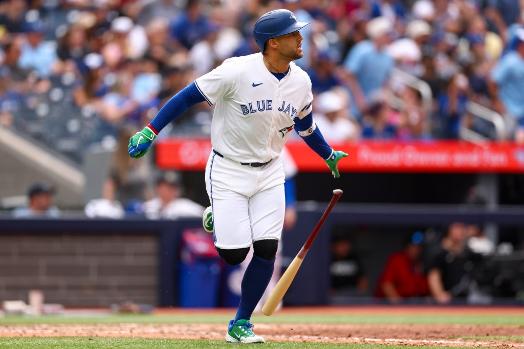 Toronto Blue Jays baseball player running after hitting a ball.