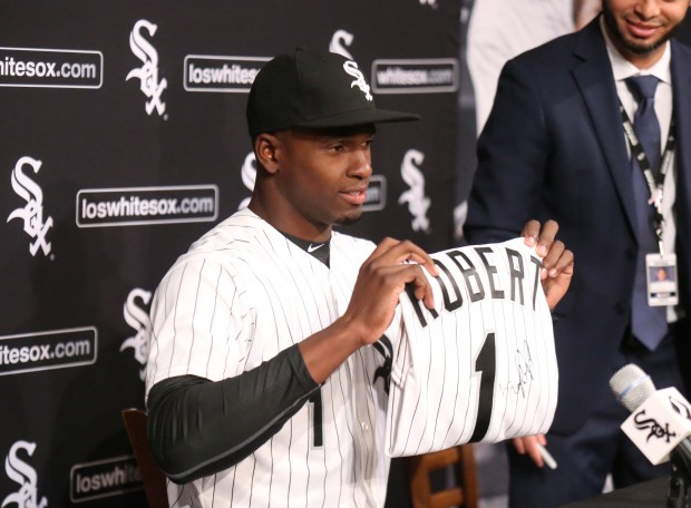 Luis Robert holds his White Sox jersey after his signing...